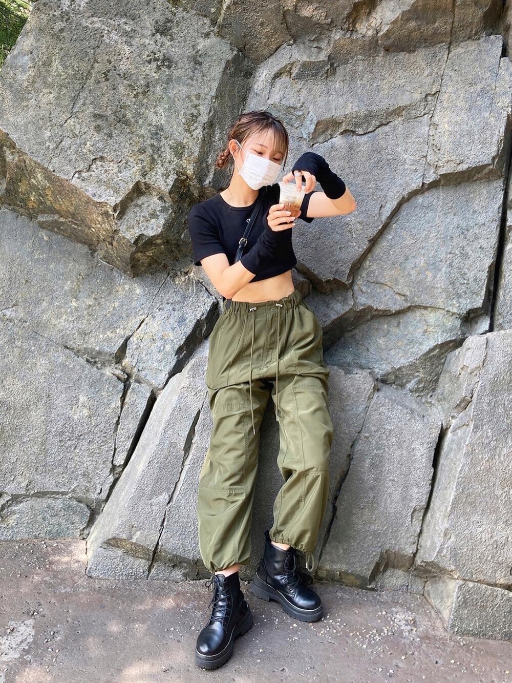 ブラック系のTシャツ/カットソー、ブラック系のブーツ、グリーン系のカーゴパンツを着用したレディースの秋コーディネートの2枚目の写真