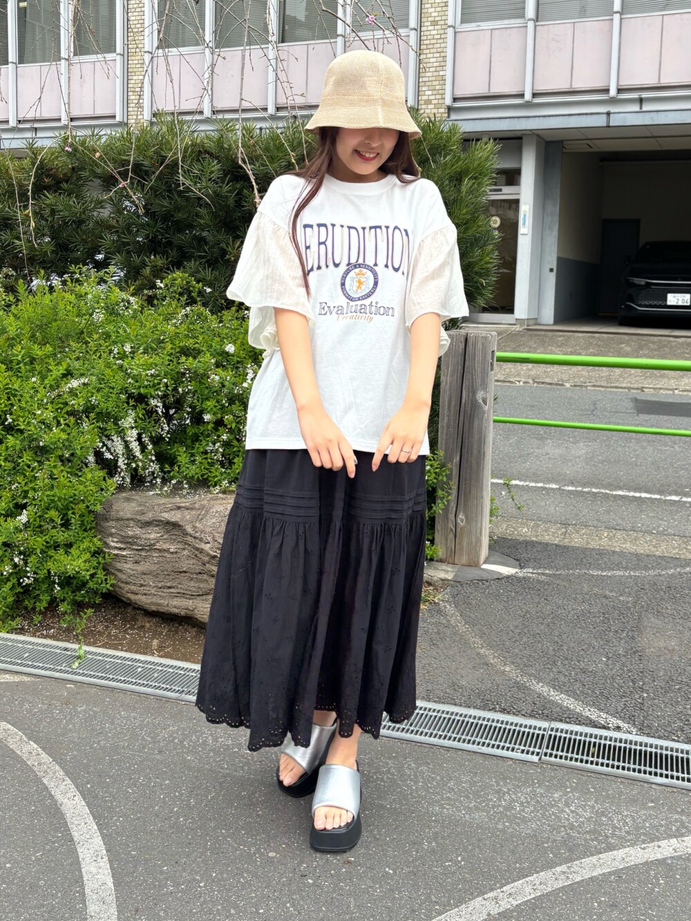 ブラック系のスカート、シルバー系のサンダル、ホワイト系のTシャツ/カットソーを着用したレディースの春コーディネートの2枚目の写真