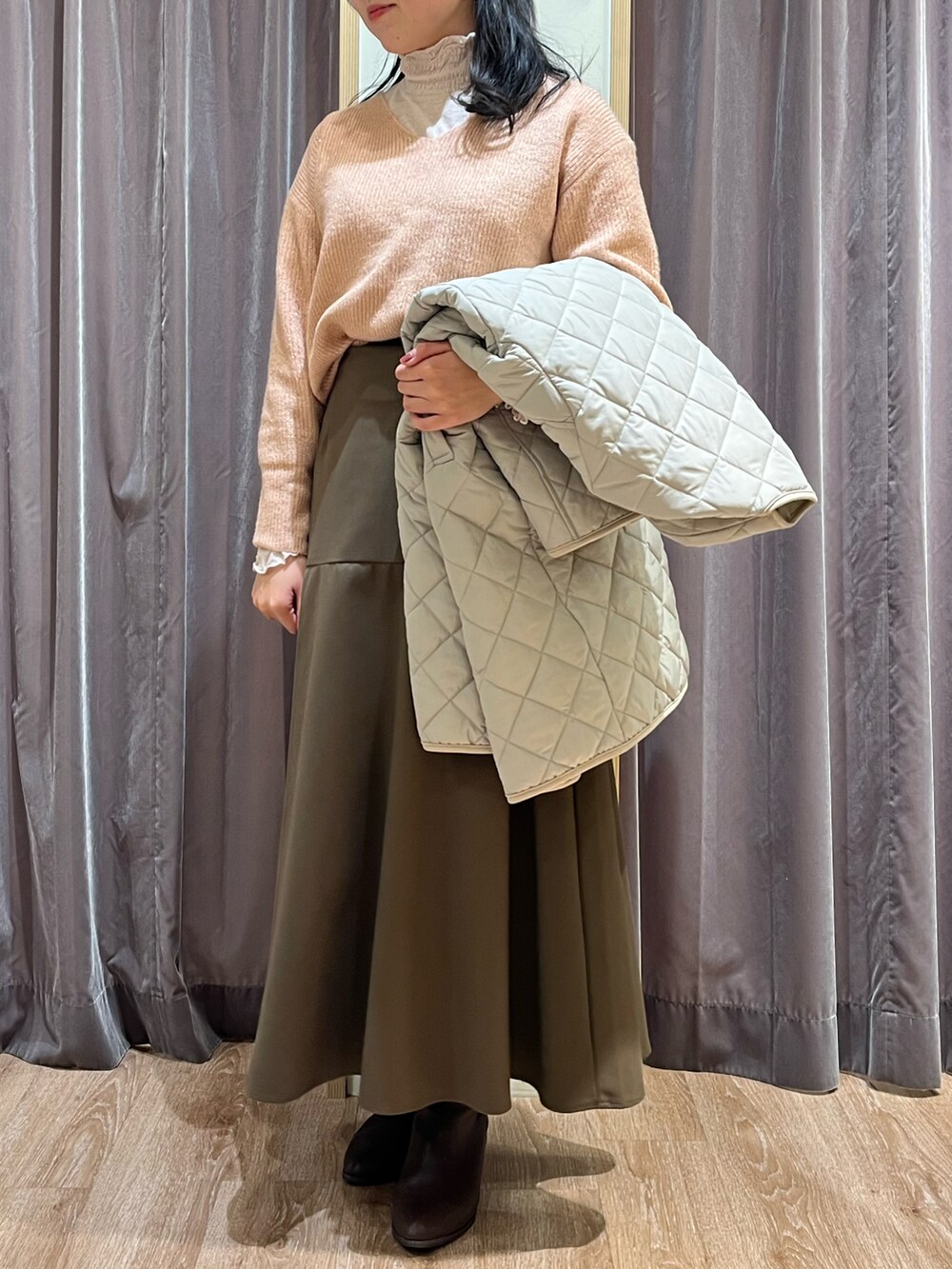 ピンク系のニット/セーター、ブラウン系のスカート、ベージュ系のTシャツ/カットソーを着用したレディースの冬コーディネートの2枚目の写真