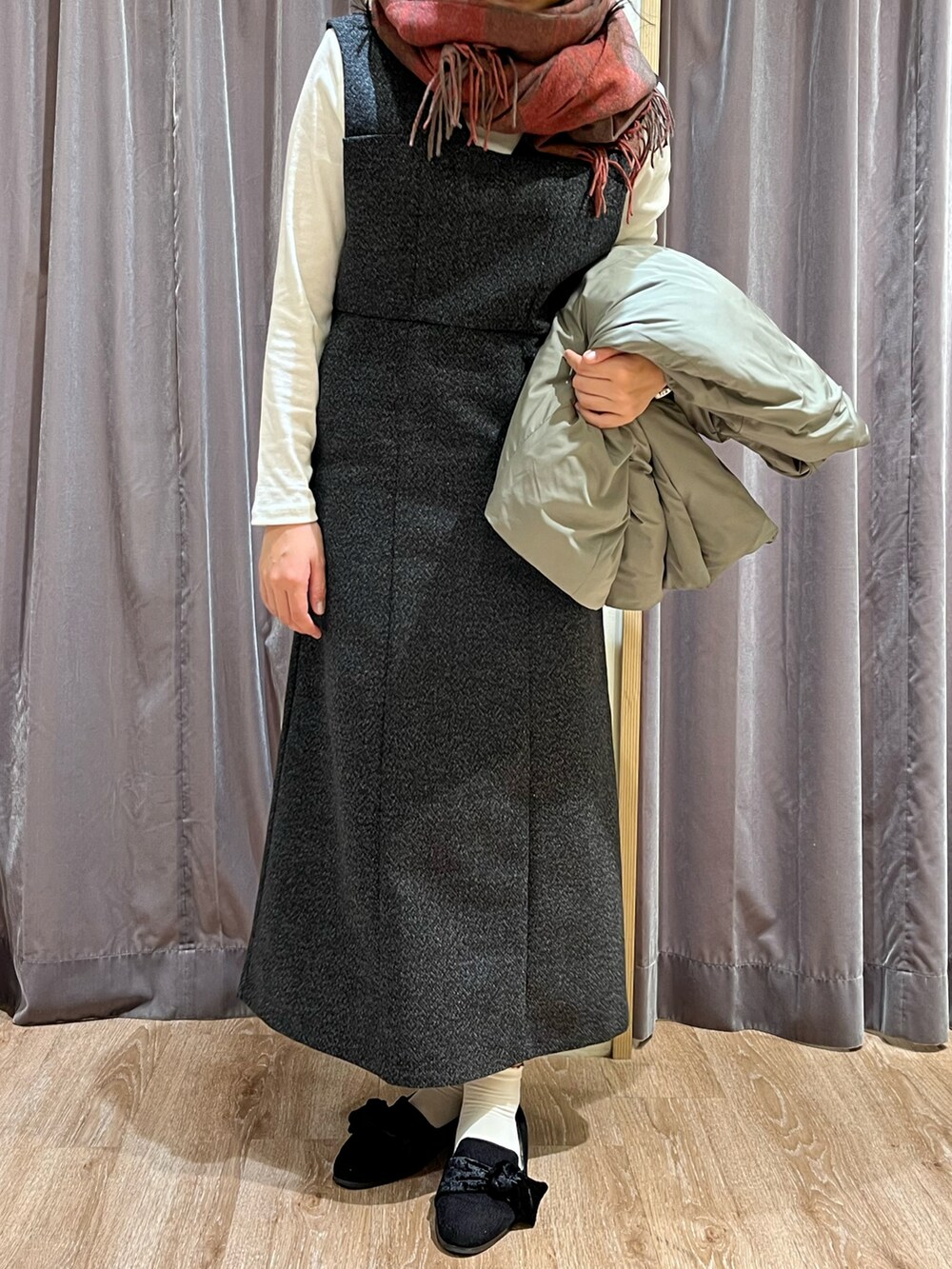 グリーン系のその他アウター、ブラック系のジャンパースカート、ブラック系のパンプスを着用したレディースの冬コーディネートの2枚目の写真