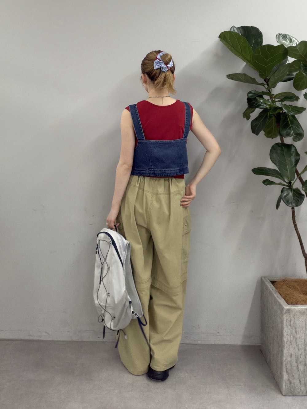 レッド系のタンクトップ、ベージュ系のその他パンツ、グレー系のその他シューズを着用したレディースの夏コーディネートの3枚目の写真