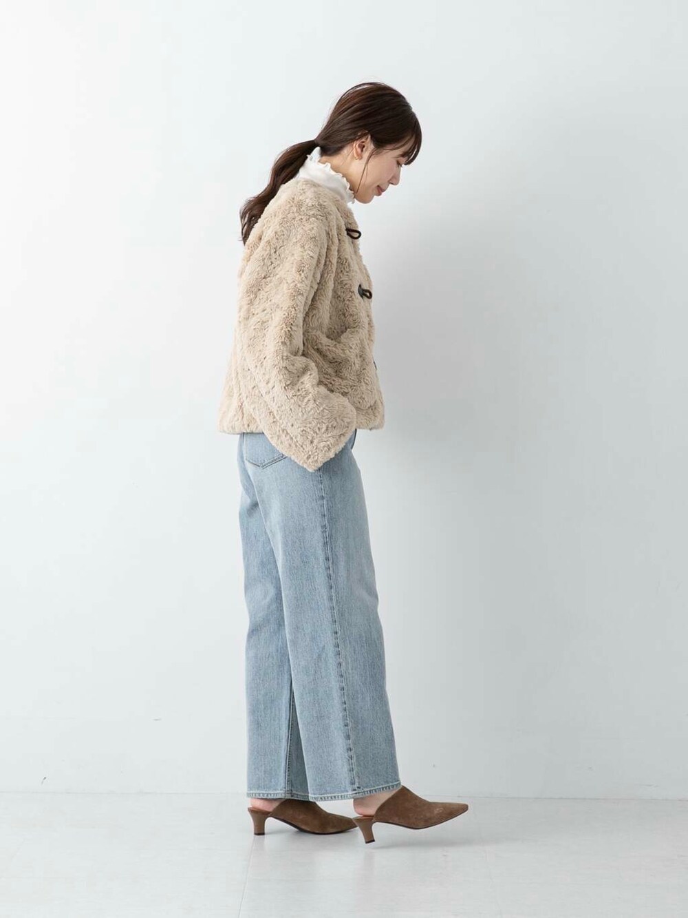 ブルー系のデニムパンツ、ブラウン系のその他シューズ、ホワイト系のその他アウターを着用したレディースの冬コーディネートの2枚目の写真