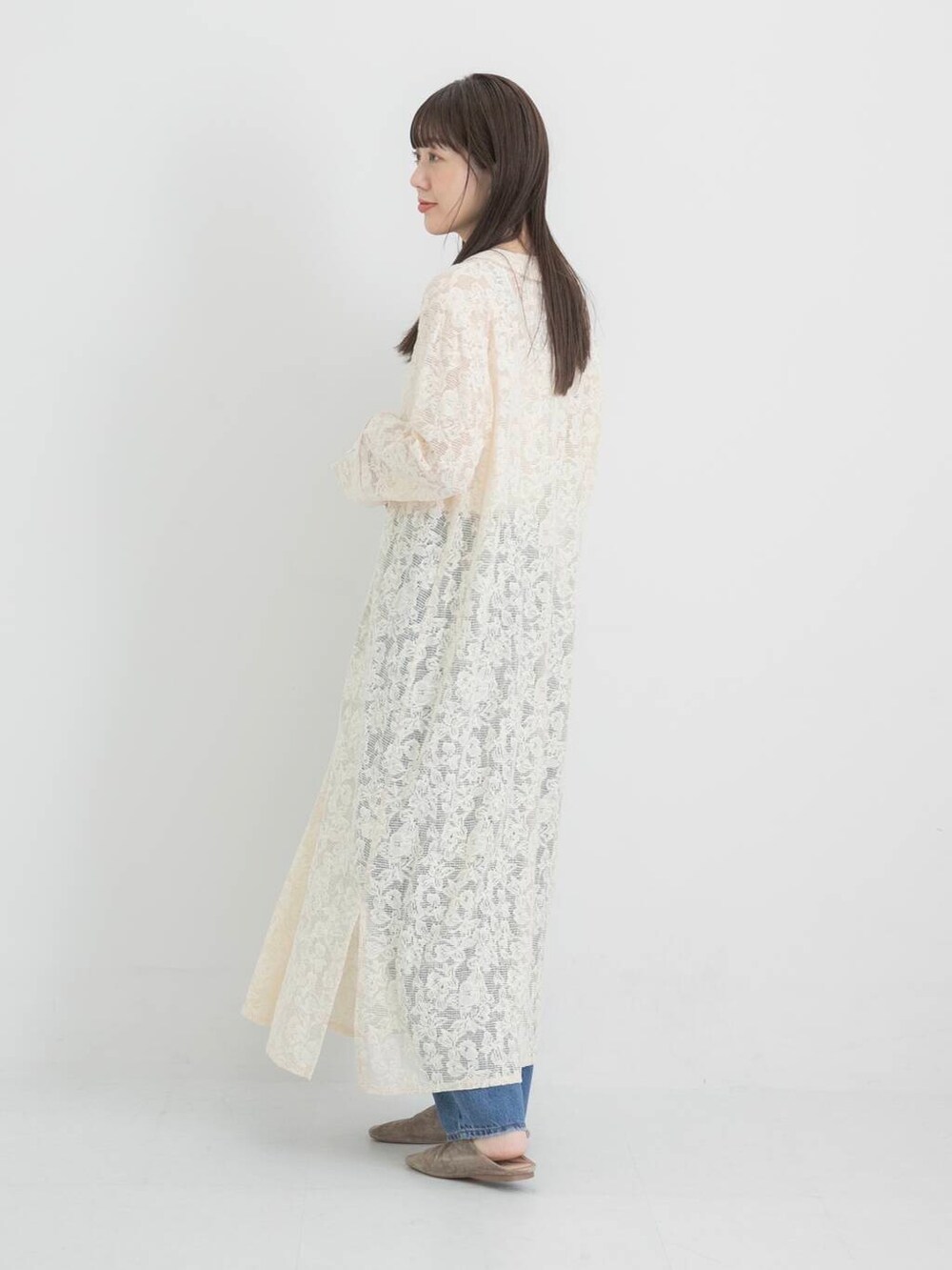 ブルー系のデニムパンツ、ホワイト系のワンピースを着用したレディースの秋コーディネートの2枚目の写真