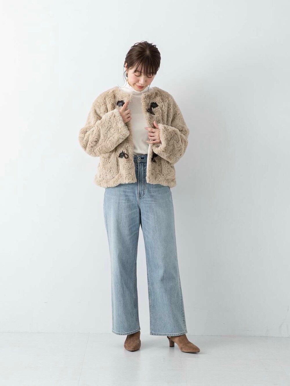 ブルー系のデニムパンツ、ブラウン系のその他シューズ、ホワイト系のその他アウターを着用したレディースの冬コーディネートの5枚目の写真