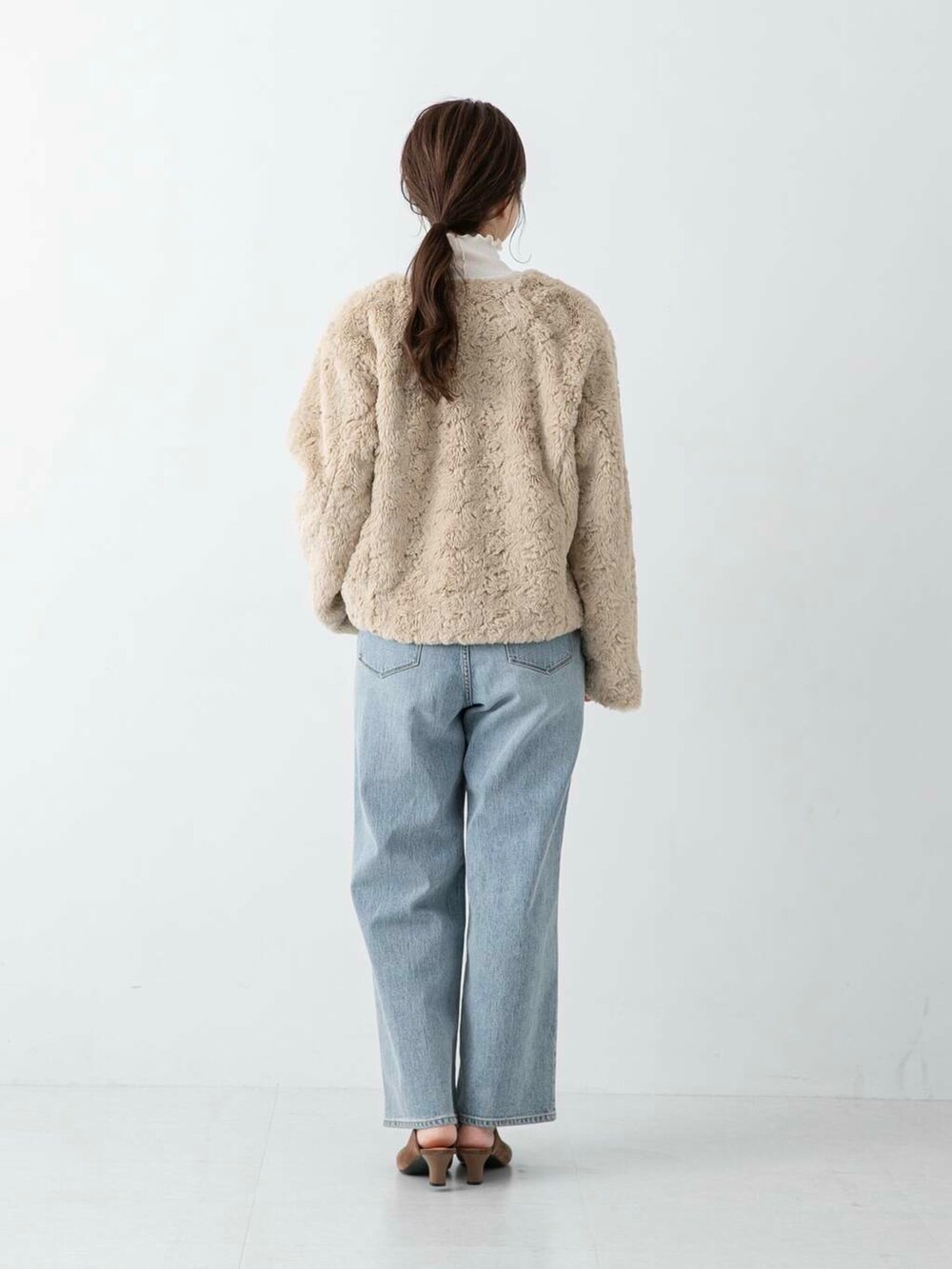 ブルー系のデニムパンツ、ブラウン系のその他シューズ、ホワイト系のその他アウターを着用したレディースの冬コーディネートの3枚目の写真