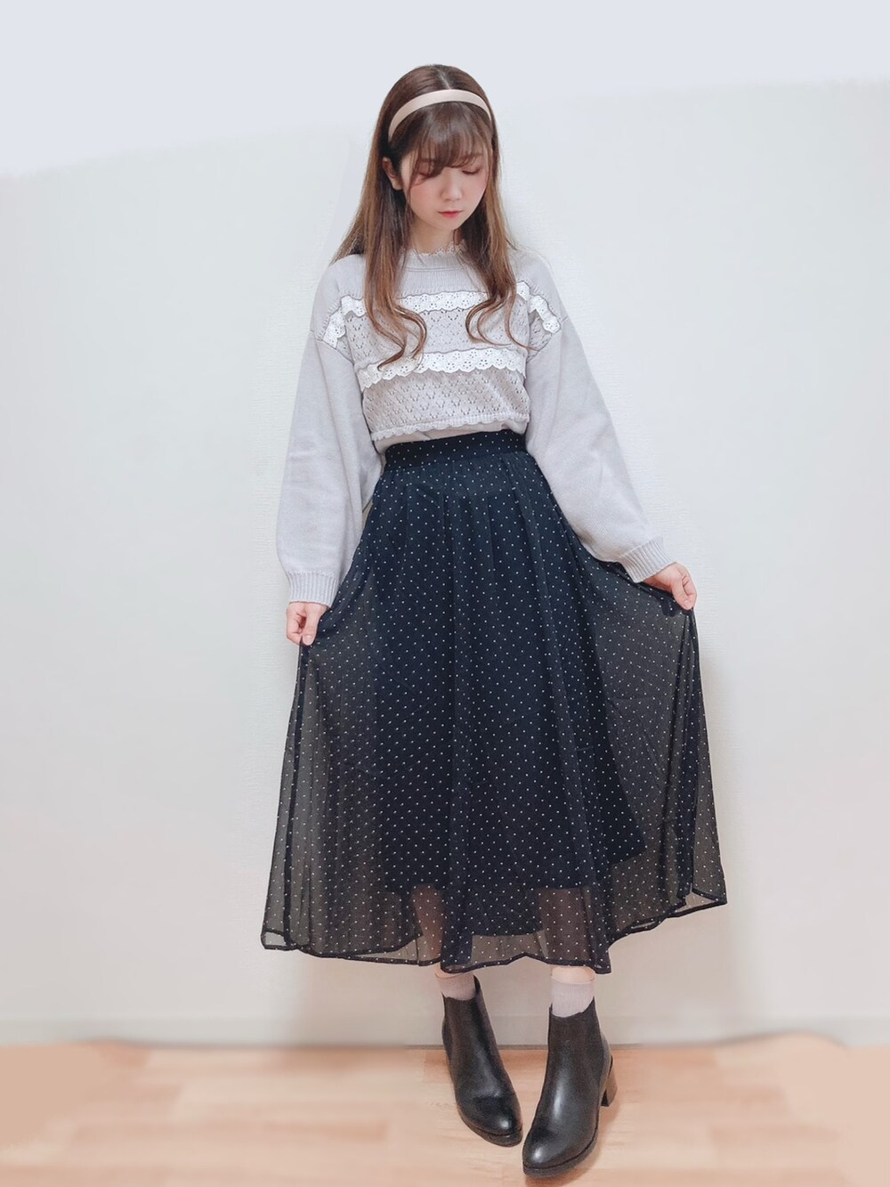 グレー系のニット/セーター、ブラック系のスカート、ホワイト系のその他アウターを着用したレディースの冬コーディネートの2枚目の写真