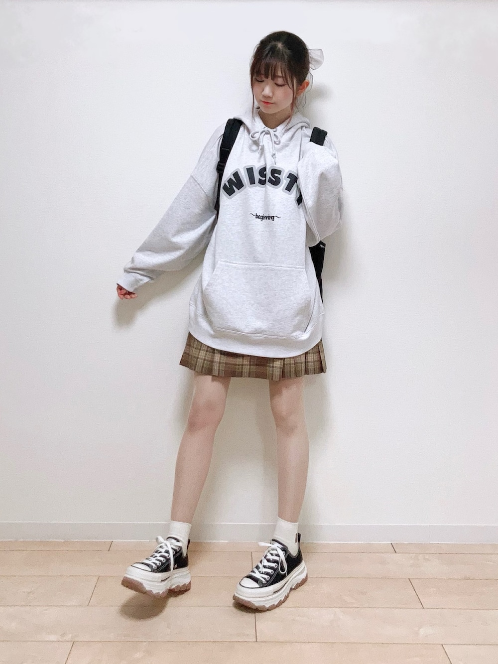 グレー系のスウェット、ブラック系のバックパック/リュック、ブラウン系のスカートを着用したレディースの秋コーディネートの3枚目の写真