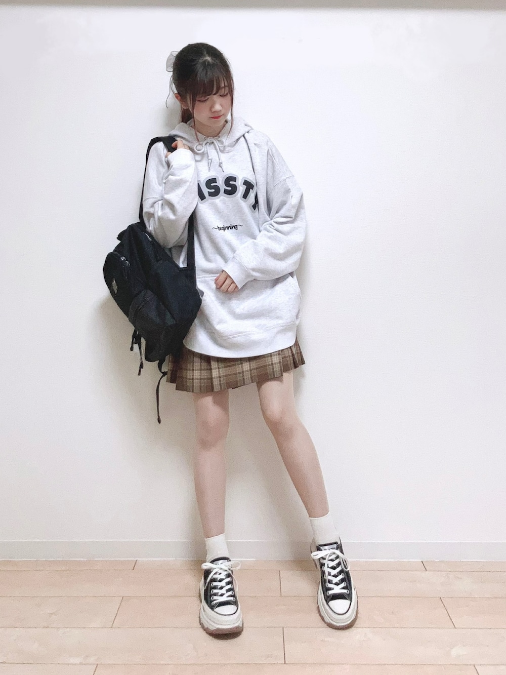 グレー系のスウェット、ブラック系のバックパック/リュック、ブラウン系のスカートを着用したレディースの秋コーディネートの5枚目の写真