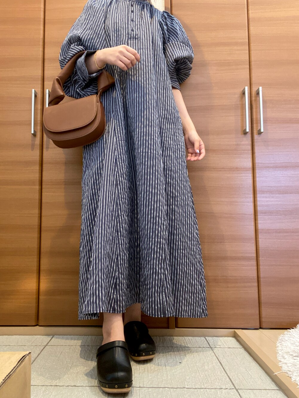 ブラック系のサンダル、ブルー系のワンピースを着用したレディースの秋コーディネートの2枚目の写真