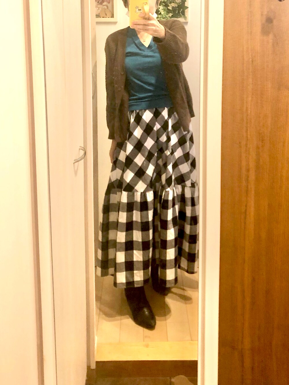 ブルー系のニット/セーター、ブラウン系のカーディガン/ボレロ、ブラック系のスカートを着用したレディースの秋コーディネートの2枚目の写真