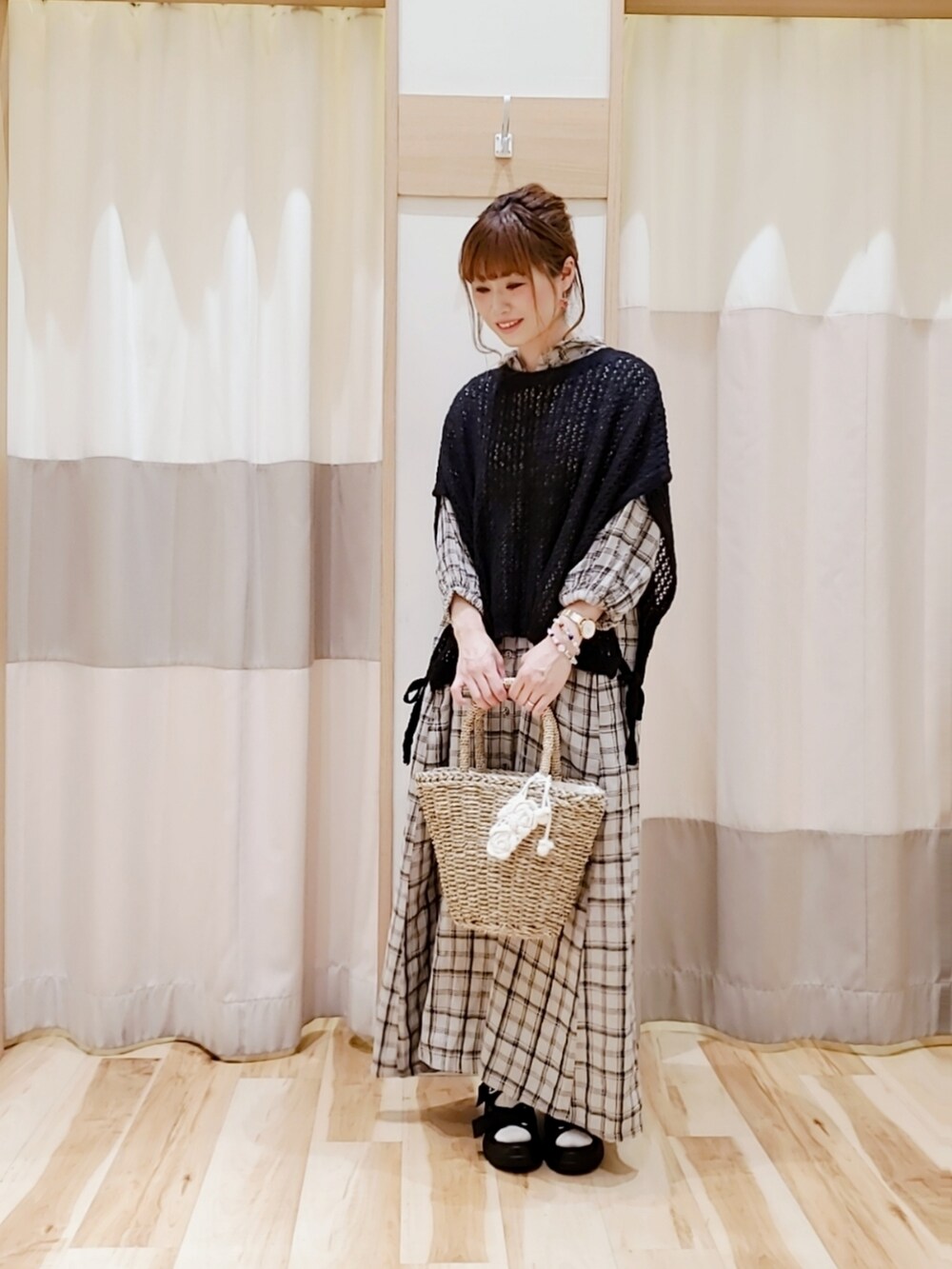 ホワイト系のかごバッグ、ブラック系のベスト、ホワイト系のワンピースを着用したレディースの夏コーディネートの2枚目の写真