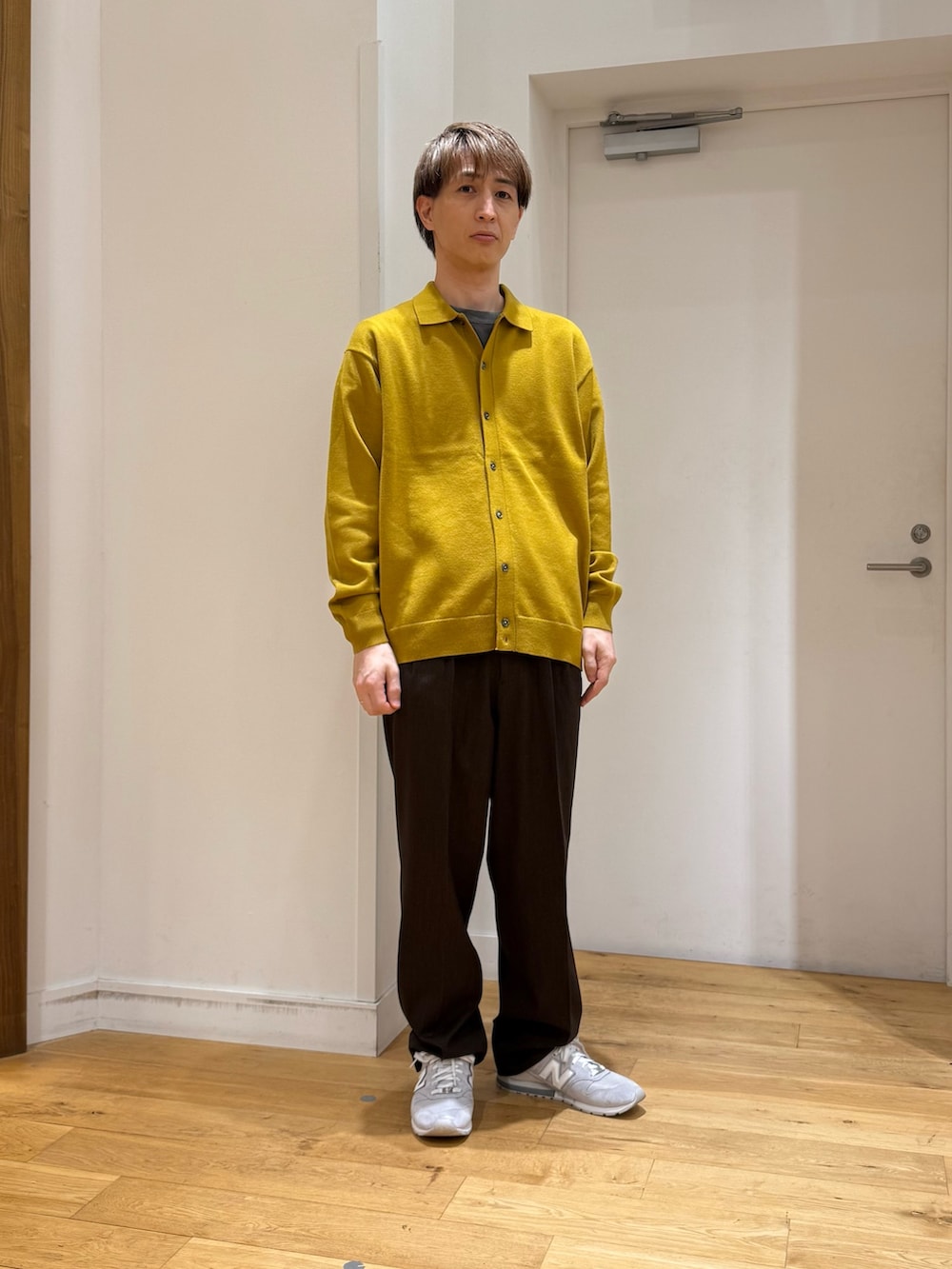 イエロー系のカーディガン/ボレロ、ブラウン系のスラックス、グレー系のスニーカーを着用したメンズの秋コーディネートの4枚目の写真