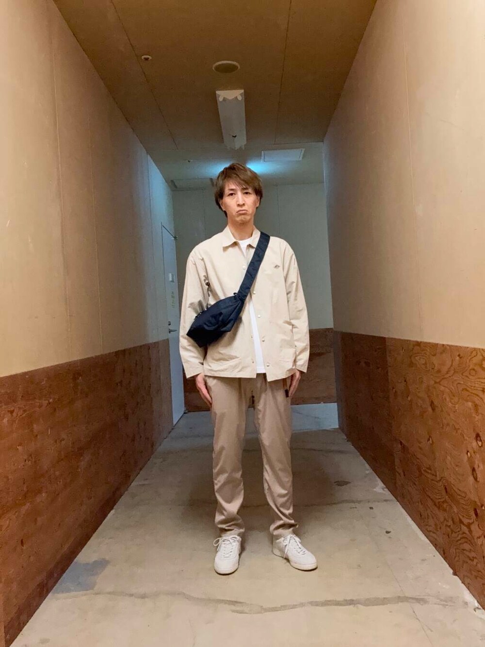ベージュ系のその他パンツ、ブラック系のショルダーバッグ、ホワイト系のTシャツ/カットソーを着用したメンズの春コーディネートの3枚目の写真