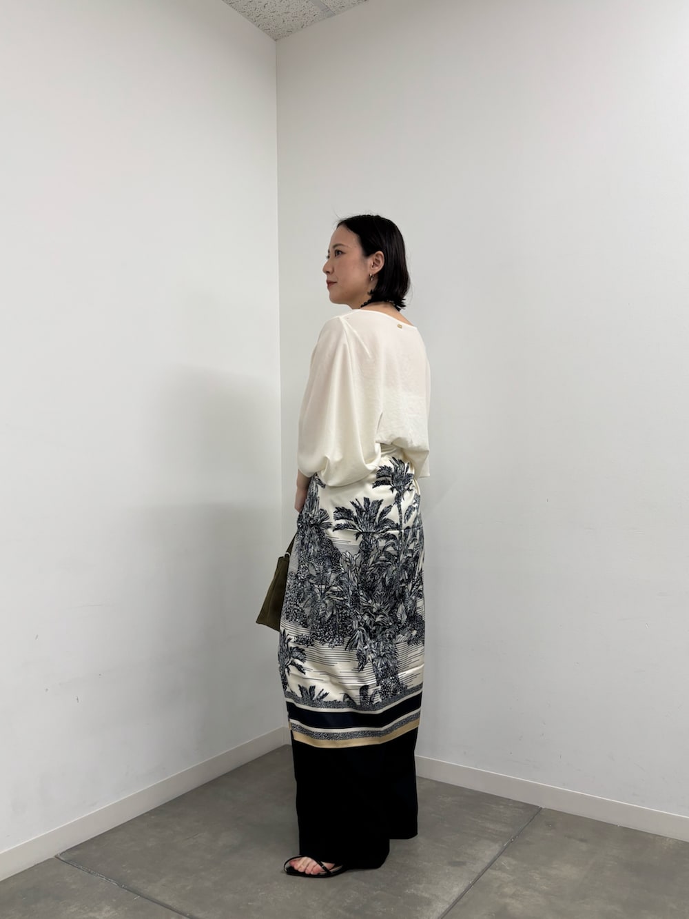 ホワイト系のシャツ/ブラウス、ブルー系のマフラー、ブラック系のネックレスを着用したレディースの春コーディネートの2枚目の写真