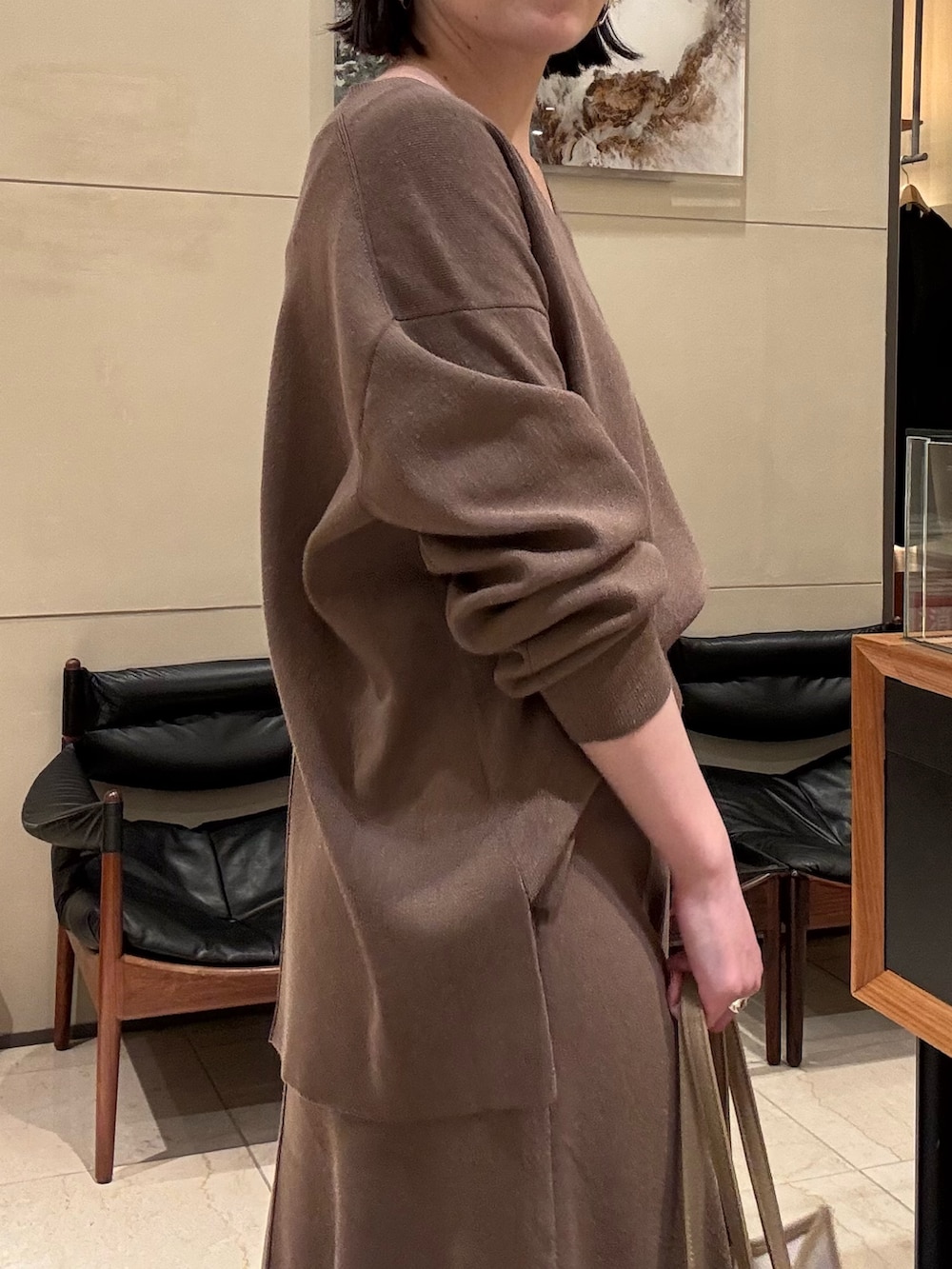 ベージュ系のニット/セーター、ベージュ系のスカート、ベージュ系のトートバッグを着用したレディースの冬コーディネートの4枚目の写真