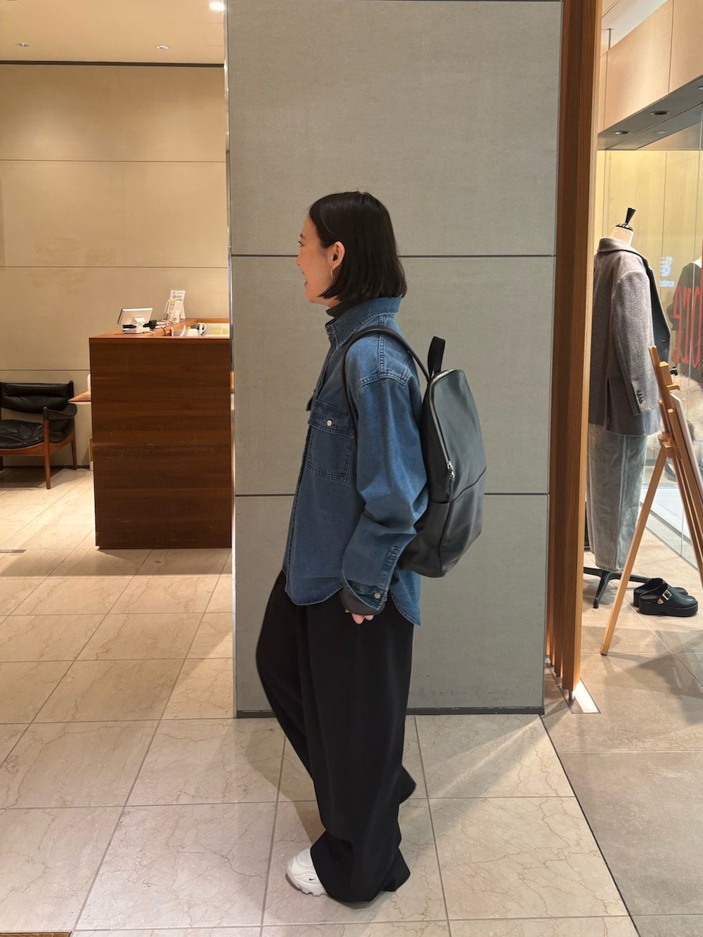 グレー系のTシャツ/カットソー、ブルー系のシャツ/ブラウス、ブラック系のバックパック/リュックを着用したレディースの冬コーディネートの2枚目の写真