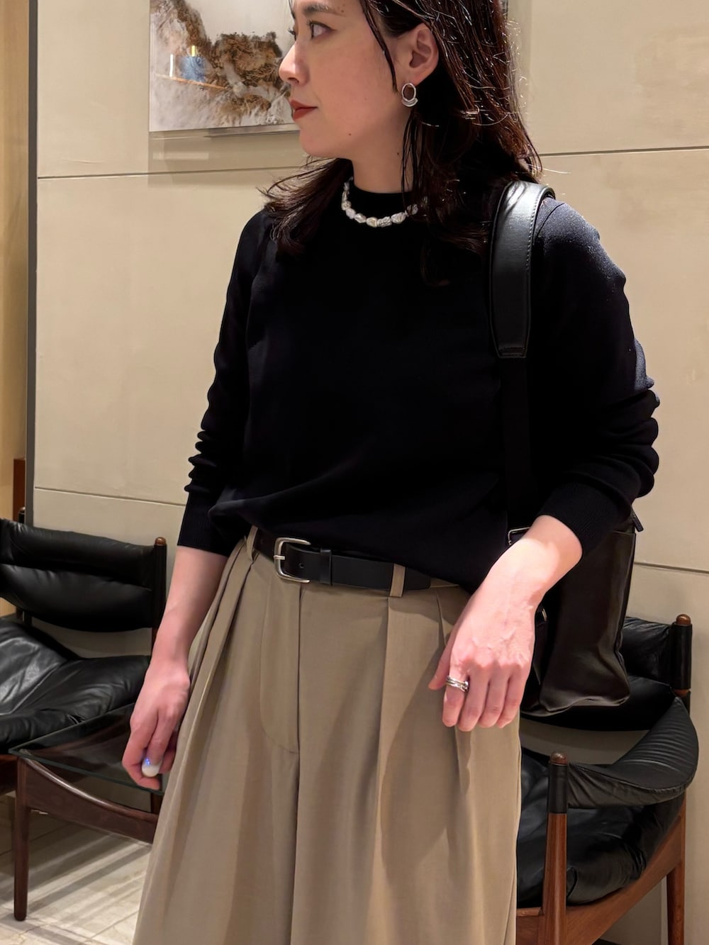 ブラック系のニット/セーター、ベージュ系のその他パンツ、ブラック系のバックパック/リュックを着用したレディースの春コーディネートの4枚目の写真