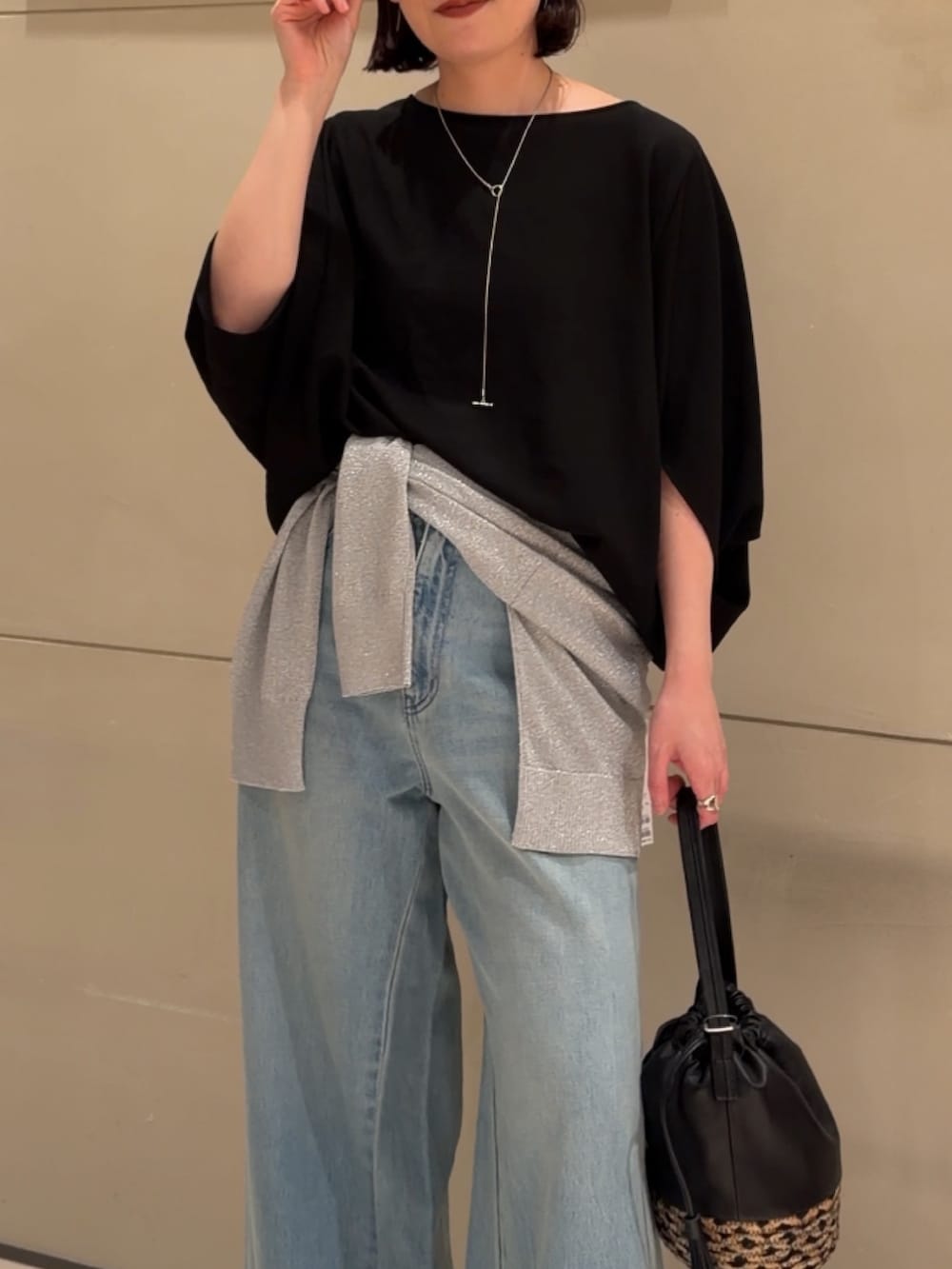 ブラック系のシャツ/ブラウス、シルバー系のニット/セーター、ブルー系のデニムパンツを着用したレディースの夏コーディネートの2枚目の写真