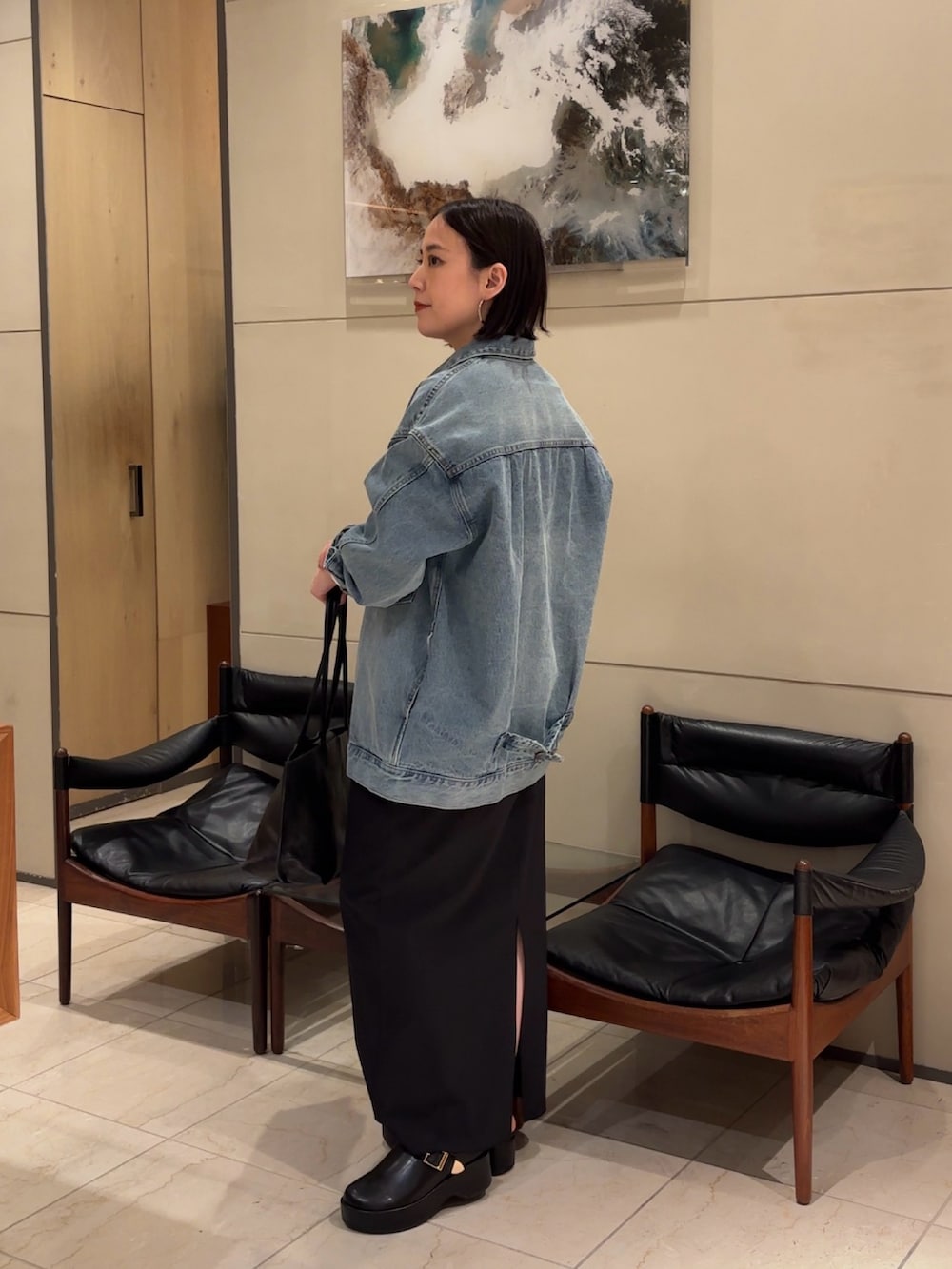 ブラック系のワンピース、ブラック系のブーツ、ブラック系のトートバッグを着用したレディースの春コーディネートの3枚目の写真