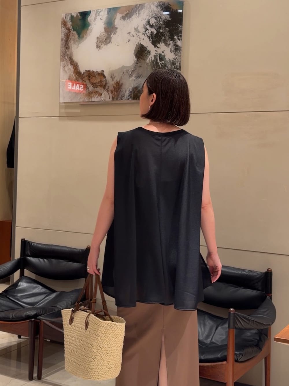 ブラック系のTシャツ/カットソー、イエロー系のスカート、ブラック系のサンダルを着用したレディースの夏コーディネートの3枚目の写真