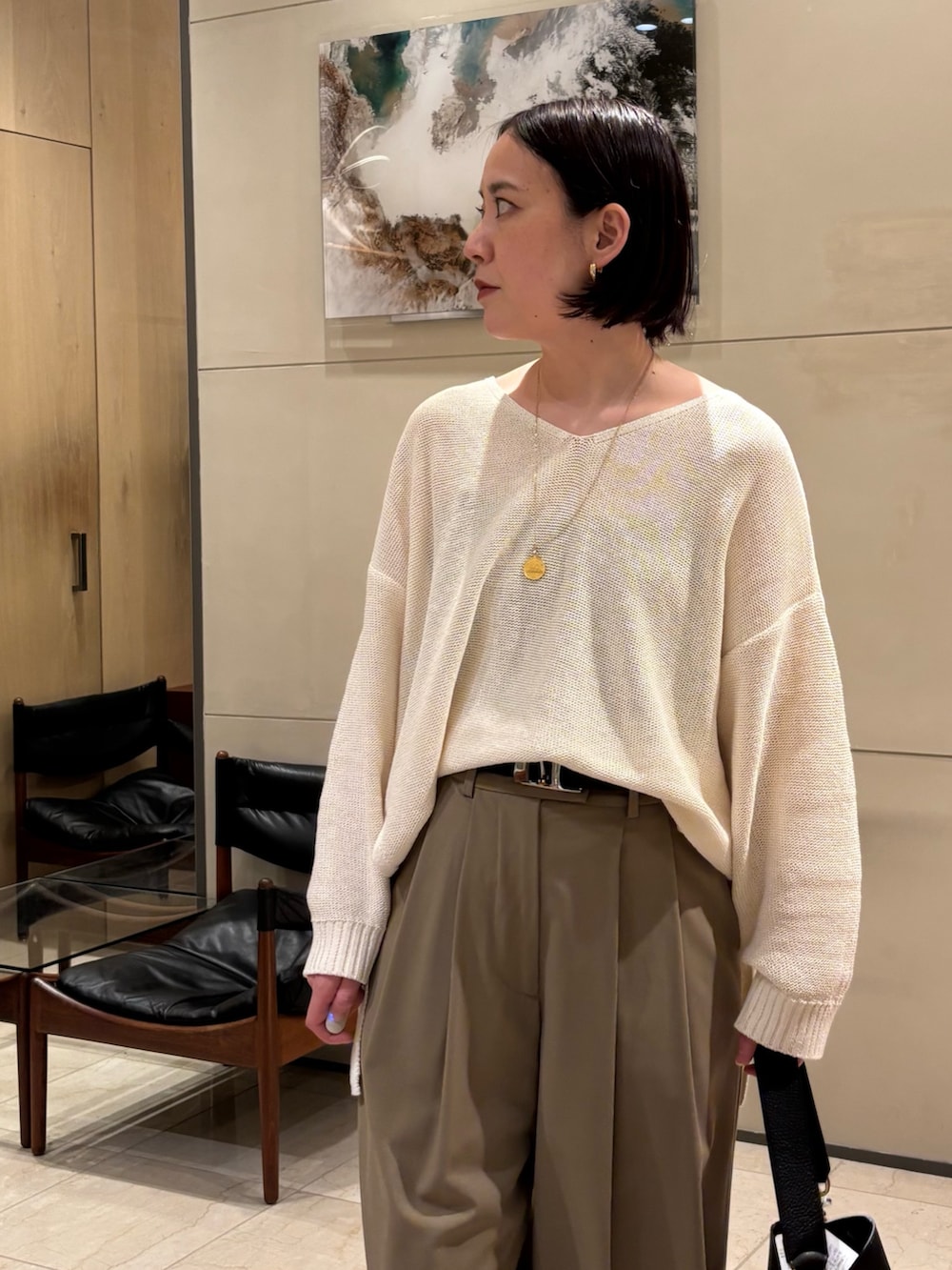 ホワイト系のニット/セーター、ベージュ系のその他パンツ、ブラック系のキャミソールを着用したレディースの春コーディネートの2枚目の写真