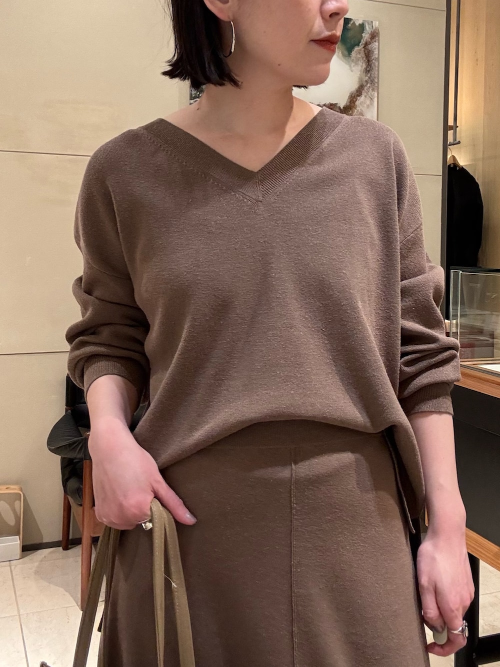 ベージュ系のニット/セーター、ベージュ系のスカート、ベージュ系のトートバッグを着用したレディースの冬コーディネートの3枚目の写真