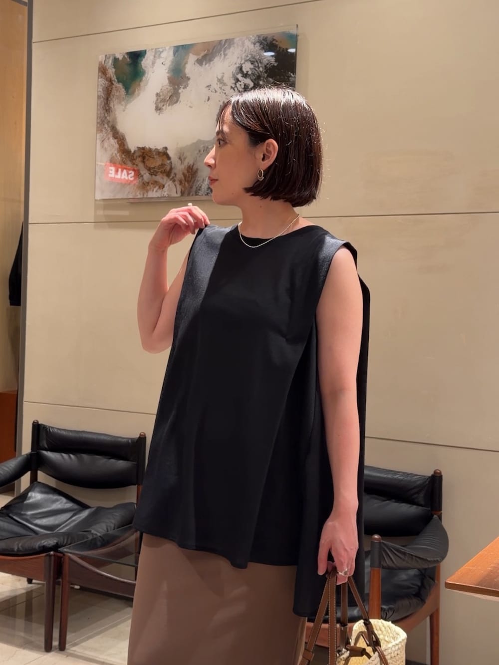 ブラック系のTシャツ/カットソー、イエロー系のスカート、ブラック系のサンダルを着用したレディースの夏コーディネートの4枚目の写真