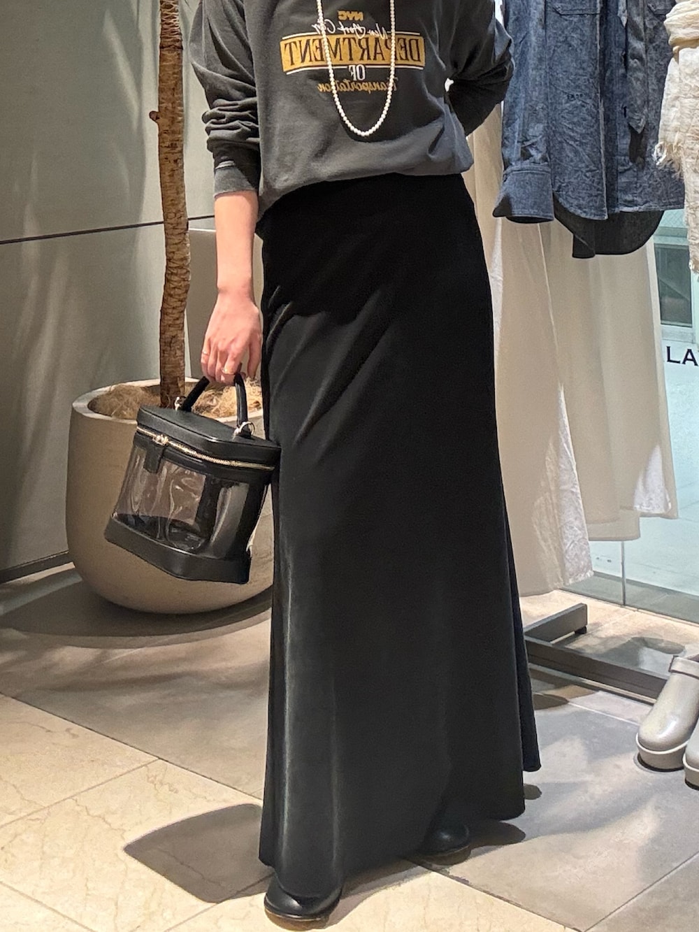 グレー系のTシャツ/カットソー、ブラック系のスカート、ブラック系のショルダーバッグを着用したレディースの春コーディネートの3枚目の写真