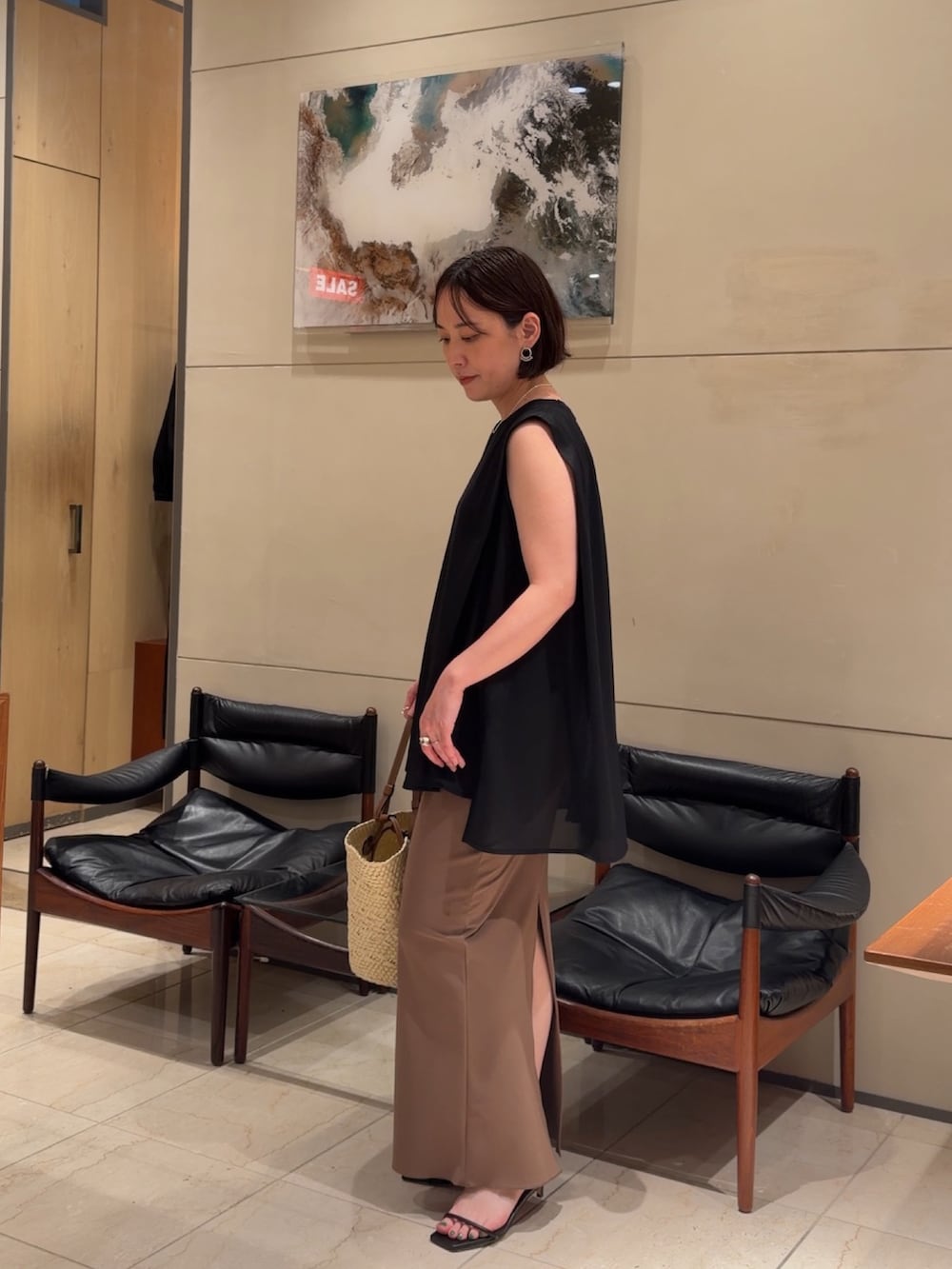 ブラック系のTシャツ/カットソー、イエロー系のスカート、ブラック系のサンダルを着用したレディースの夏コーディネートの2枚目の写真