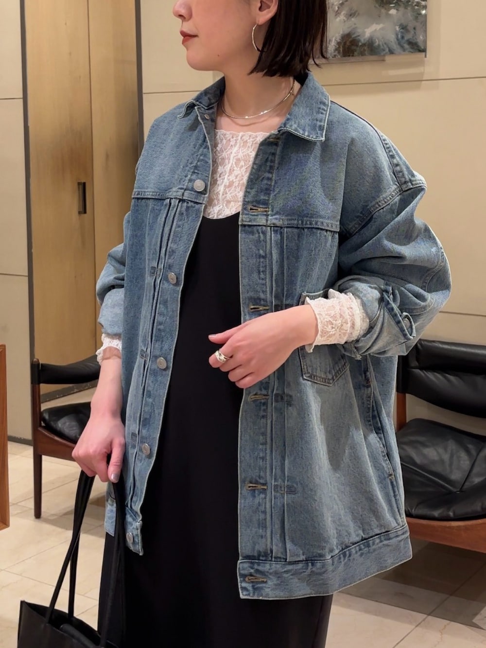 ブラック系のワンピース、ブラック系のブーツ、ブラック系のトートバッグを着用したレディースの春コーディネートの4枚目の写真