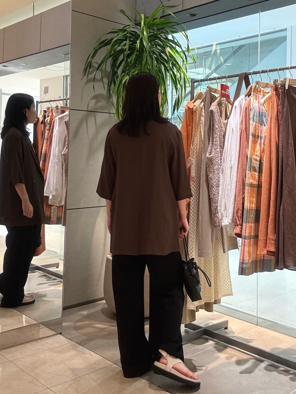 ブラウン系のテーラードジャケット、ベージュ系のニット/セーター、ブラック系のその他パンツを着用したレディースの夏コーディネートの2枚目の写真