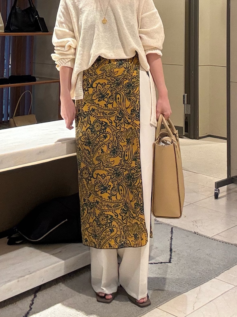 ホワイト系のニット/セーター、ホワイト系のその他パンツ、ベージュ系のトートバッグを着用したレディースの春コーディネートの4枚目の写真