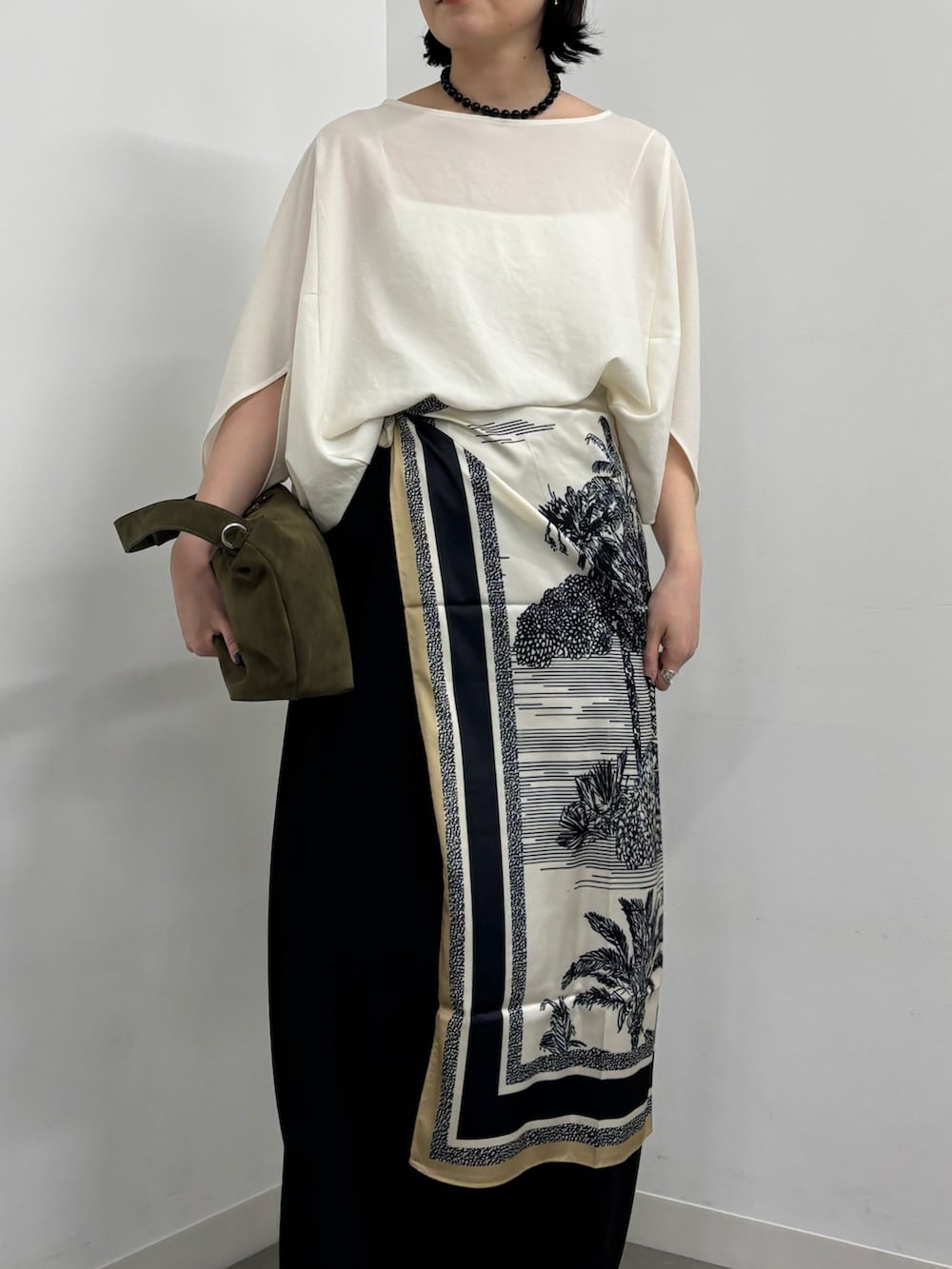 ホワイト系のシャツ/ブラウス、ブルー系のマフラー、ブラック系のネックレスを着用したレディースの春コーディネートの3枚目の写真