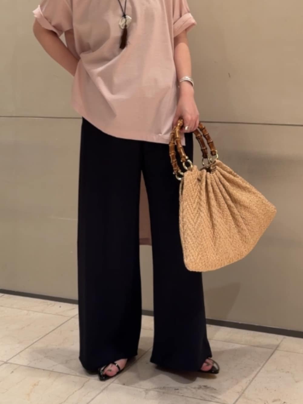 ピンク系のシャツ/ブラウス、ブラック系のその他パンツ、ベージュ系のかごバッグを着用したレディースの夏コーディネートの2枚目の写真