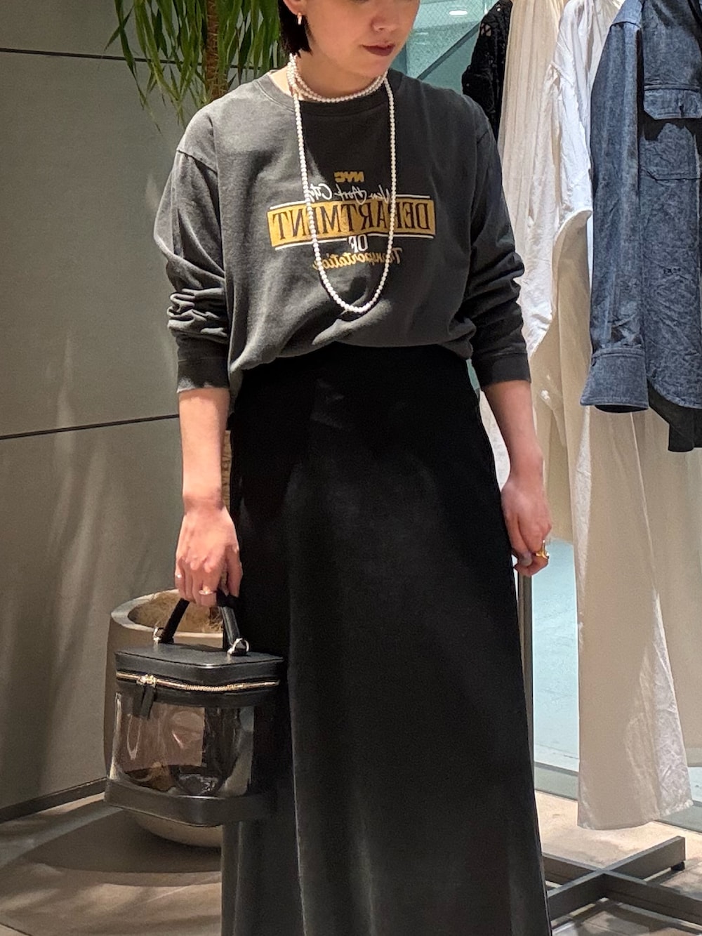 グレー系のTシャツ/カットソー、ブラック系のスカート、ブラック系のショルダーバッグを着用したレディースの春コーディネートの2枚目の写真