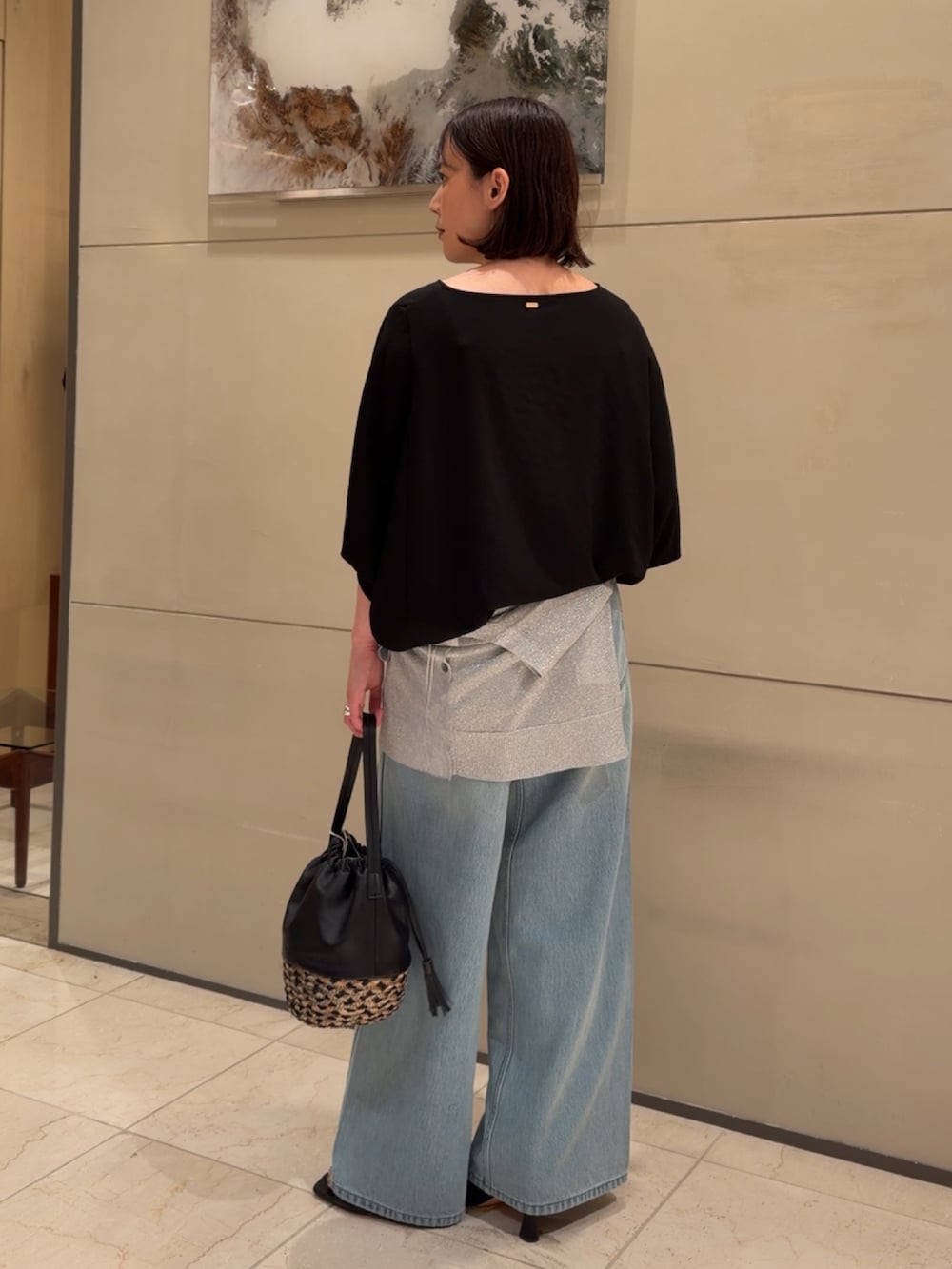 ブラック系のシャツ/ブラウス、シルバー系のニット/セーター、ブルー系のデニムパンツを着用したレディースの夏コーディネートの3枚目の写真