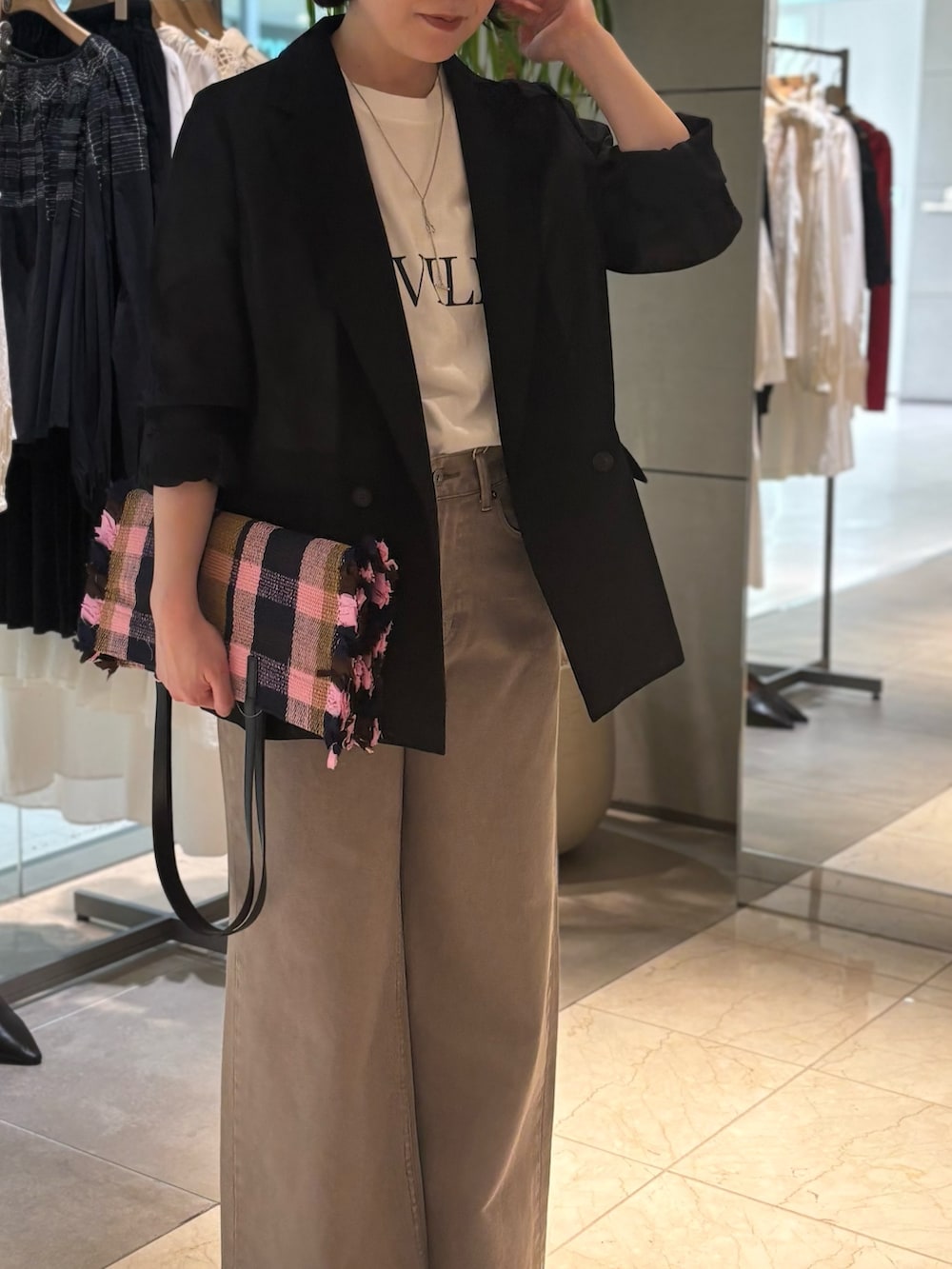 ブラック系のテーラードジャケット、ブラウン系のデニムパンツ、ブラウン系のサンダルを着用したレディースの春コーディネートの4枚目の写真