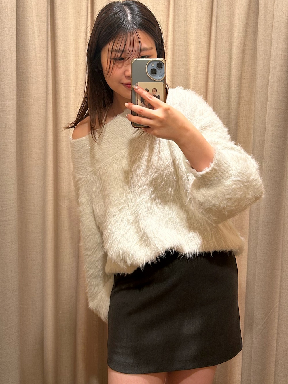 ホワイト系のニット/セーター、グレー系のスカート、ブラック系のブーツを着用したレディースの冬コーディネートの3枚目の写真