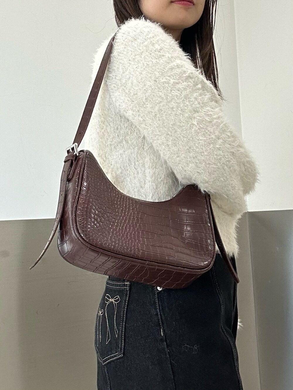 ブラウン系のブルゾン、ブラック系のデニムパンツ、ブラウン系のショルダーバッグを着用したレディースの冬コーディネートの4枚目の写真