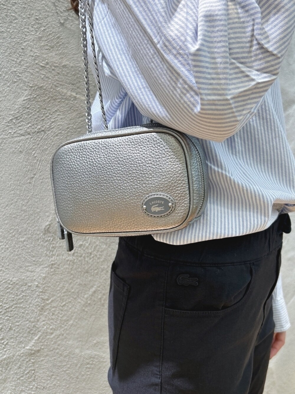 「ダウン、シャツ、キャンバスシューズ、チェーンバッグ、ストライプシャツ」｜「LACOSTEのタイムラインクロックストライプオックスフォードシャツ（シャツ/ブラウス、ブルー系）」を使った、momoさん（レディース・166cm）の春コーディネートの7枚目の写真