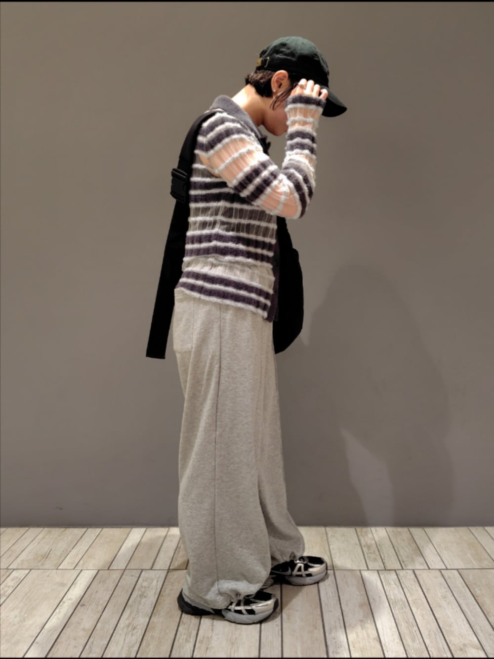 ブラック系のショルダーバッグ、グレー系のニット/セーター、グレー系のその他パンツを着用したレディースの夏コーディネートの2枚目の写真