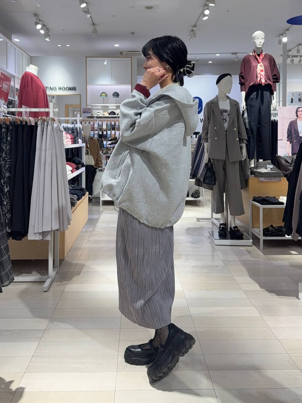 ブラック系のスニーカー、ブラウン系のスウェット、グレー系のスカートを着用したレディースの秋コーディネートの2枚目の写真