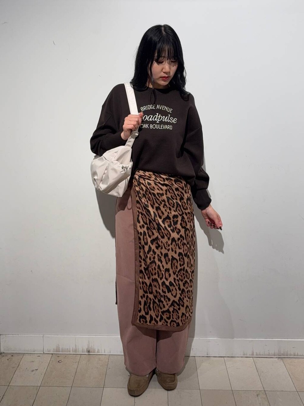 グレー系のチェスターコート、ピンク系のその他パンツ、ブラウン系のモカシン/デッキシューズを着用したレディースの秋コーディネートの2枚目の写真