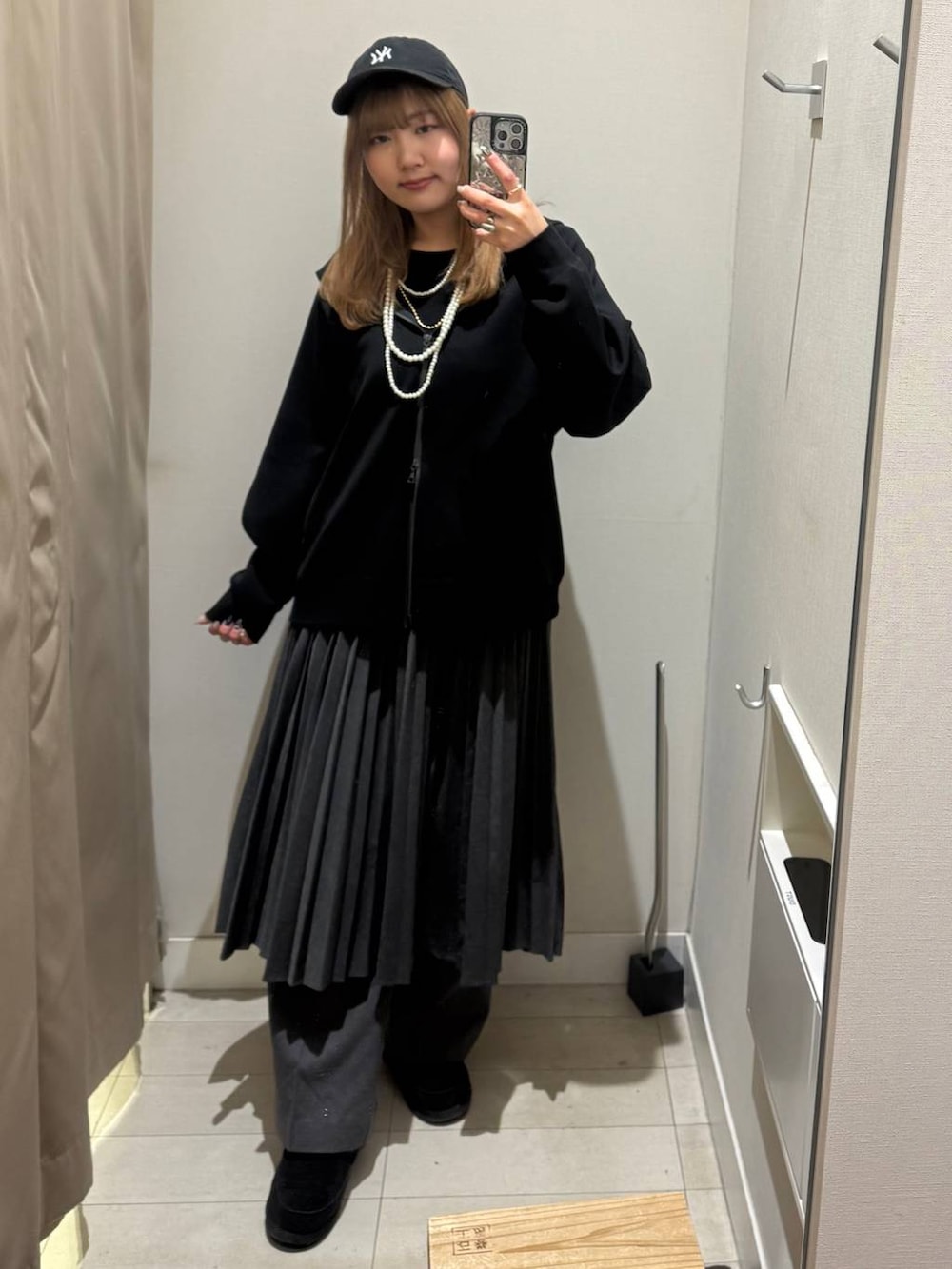 グレー系のその他パンツ、グレー系のスカート、ブラック系のパーカーを着用したレディースの冬コーディネートの3枚目の写真