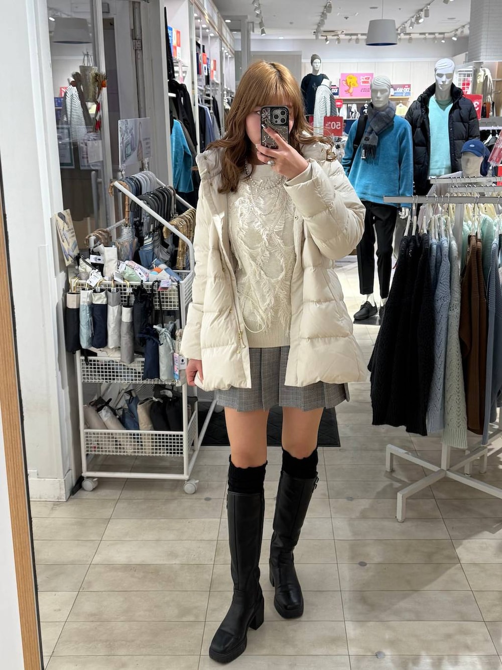 ベージュ系のダウンジャケット/コート、ブラック系のブーツ、シルバー系のネックレスを着用したレディースの冬コーディネートの4枚目の写真