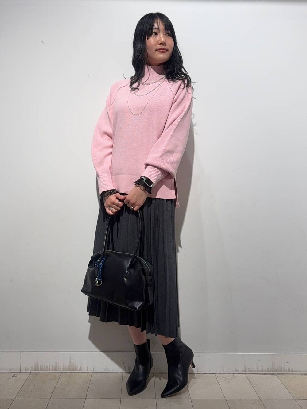 ブラック系のボストンバッグ、ブラック系のTシャツ/カットソー、ピンク系のニット/セーターを着用したレディースの冬コーディネートの5枚目の写真