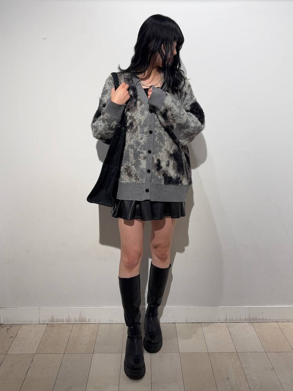 シルバー系のトートバッグ、ブラック系のブーツ、グレー系のワンピースを着用したレディースの秋コーディネートの4枚目の写真