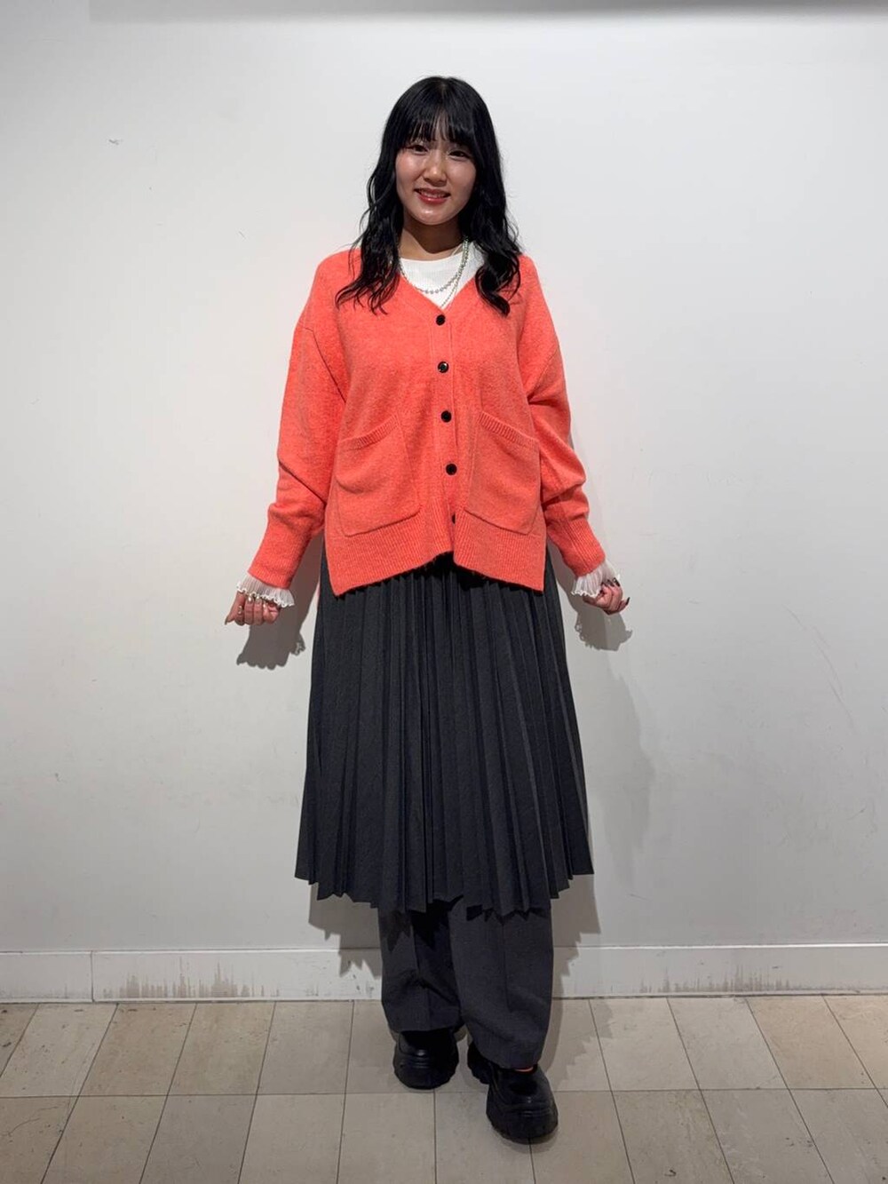 シルバー系のトートバッグ、ブラック系のスニーカー、ホワイト系のTシャツ/カットソーを着用したレディースの秋コーディネートの4枚目の写真