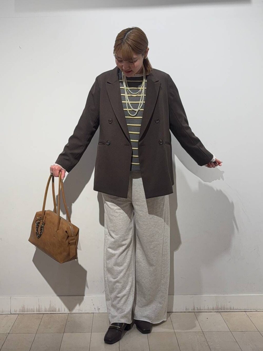 ブラウン系のローファー、ブラウン系のボストンバッグ、ホワイト系のTシャツ/カットソーを着用したレディースの冬コーディネートの5枚目の写真