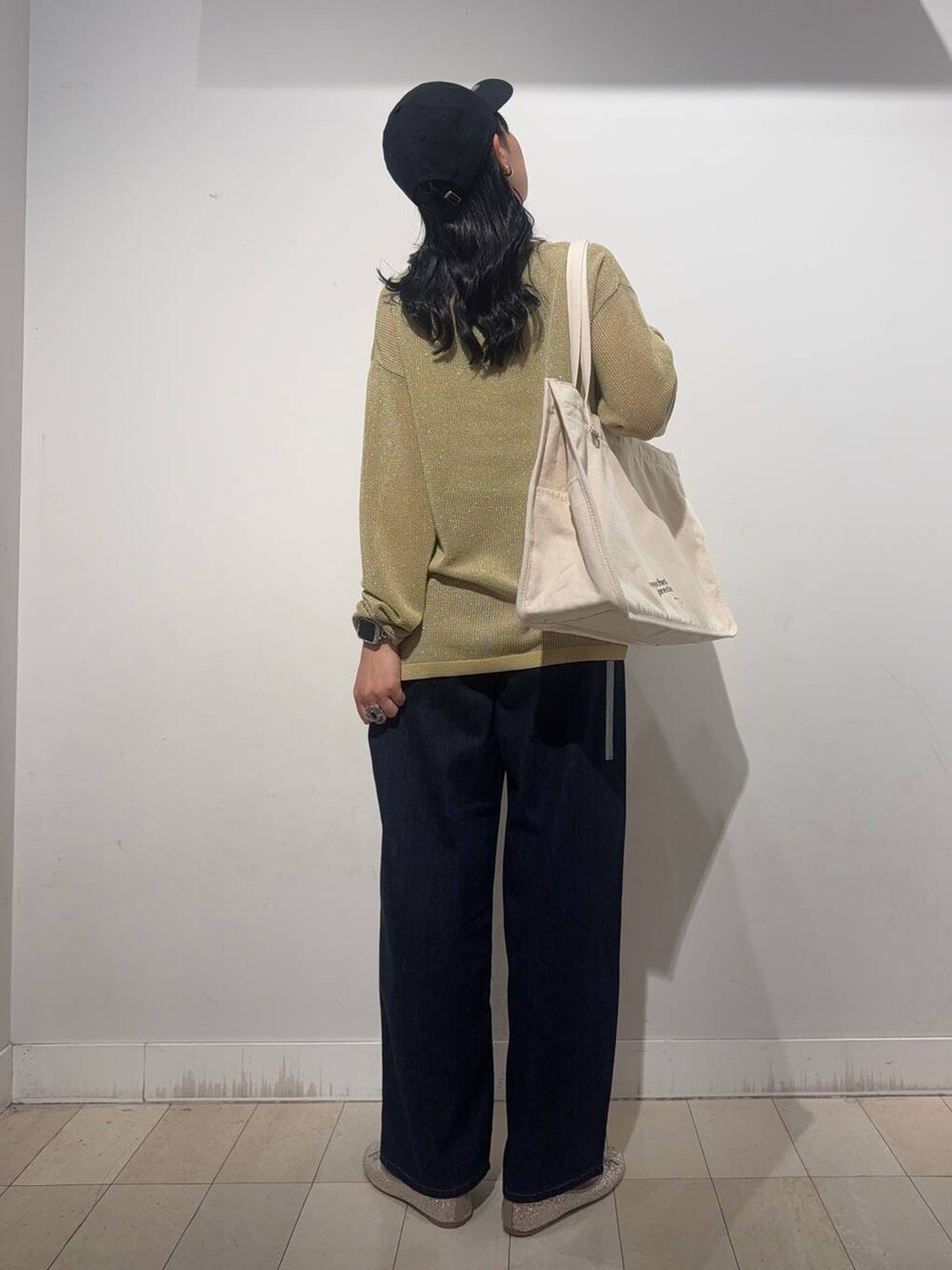 ゴールド系のバレエシューズ、イエロー系のニット/セーター、ブラック系のデニムパンツを着用したレディースの秋コーディネートの2枚目の写真